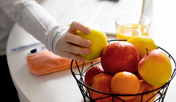 Frau greift Apfel Vitamin-C-Tagesbedarf durch Obst